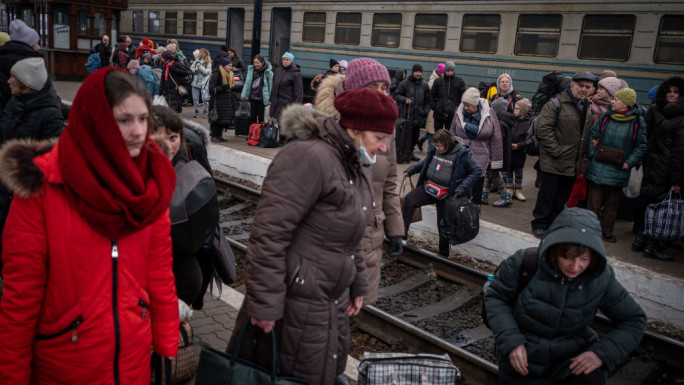 People arrive at the railway station of the western Ukrainian city of Lviv to board a train to leave the country on March 7, 2022