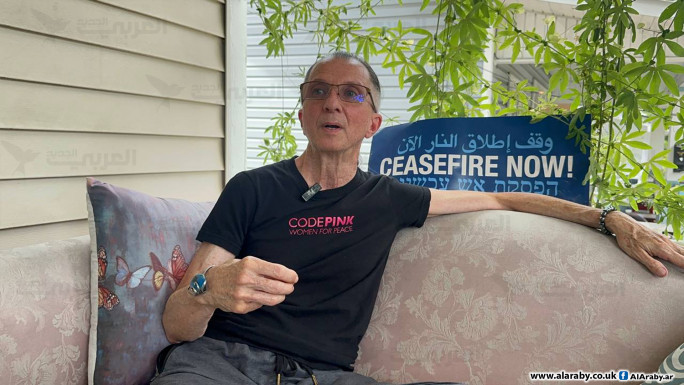 Man wearing black t shirt on sofa with poster in background