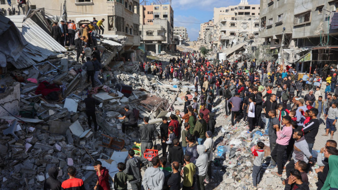 People gathered around the rubble of destroyed houses to search for survivors [Getty]