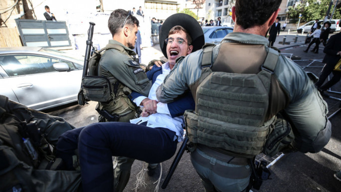 Israeli police officers intervene in Ultra-Orthodox Jews, also known as Haredim, who gather to stage a protest against mandatory military service in West Jerusalem, Israel, on August 21, 2024. (Photo by Saeed Qaq/NurPhoto via Getty Images)