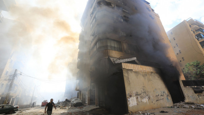 Firefighters work as smoke billows at the site of an overnight Israeli airstrike in Beirut's southern suburb of Hadath area on 2 October