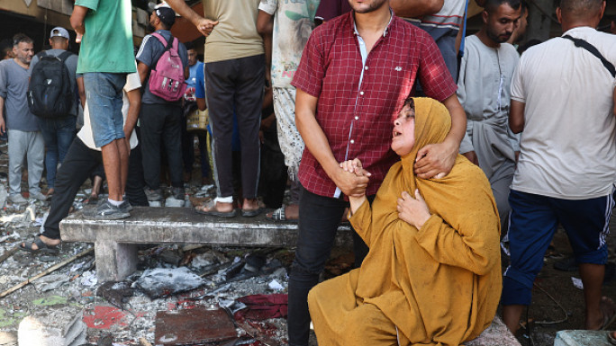 Palestinians react after an Israeli airstrike hit the Rafida school sheltering displaced people in Deir al-Balah in the central Gaza Strip on October 10, 2024. (Photo by EYAD BABA/AFP via Getty Images)