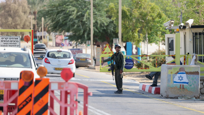 An Israeli soldier stands at a checkpoint at the entrance of Ein Tamar in southern Israel where the army said two attackers entered the area from Jordan