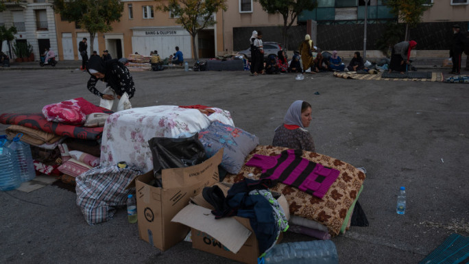 A woman is seen sitting next to her belongings on a street of Beirut. (Photo by Ashley Chan/SOPA Images/LightRocket via Getty Images)