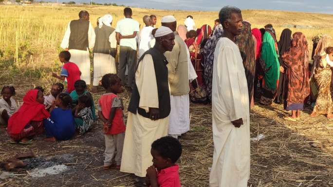 Men, women and children gathered in a field