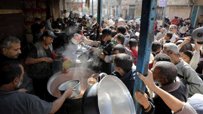 Palestinians, including children, living in the Nuseirat refugee camp wait with empty pots to receive food distributed by an aid organization as they are unable to meet many vital needs, including basic food supplies, in Gaza City, Gaza on November 08, 2024. 