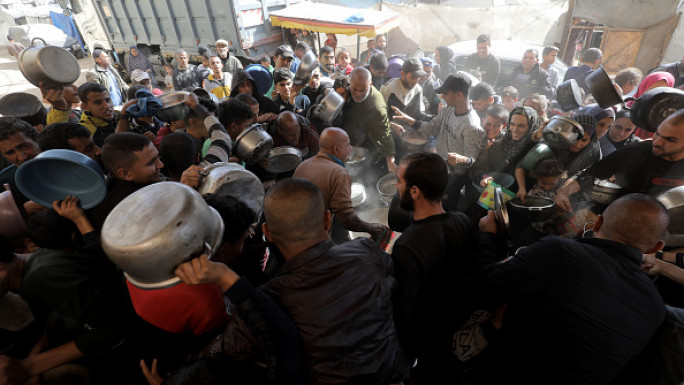 Palestinians, who take refuge in Bureij Refugee Camp to escape from Israeli attacks, wait to receive meal, distributed by charity organizations in Deir al-Balah, Gaza on November 20, 2024. (Photo by Moiz Salhi/Anadolu via Getty Images)