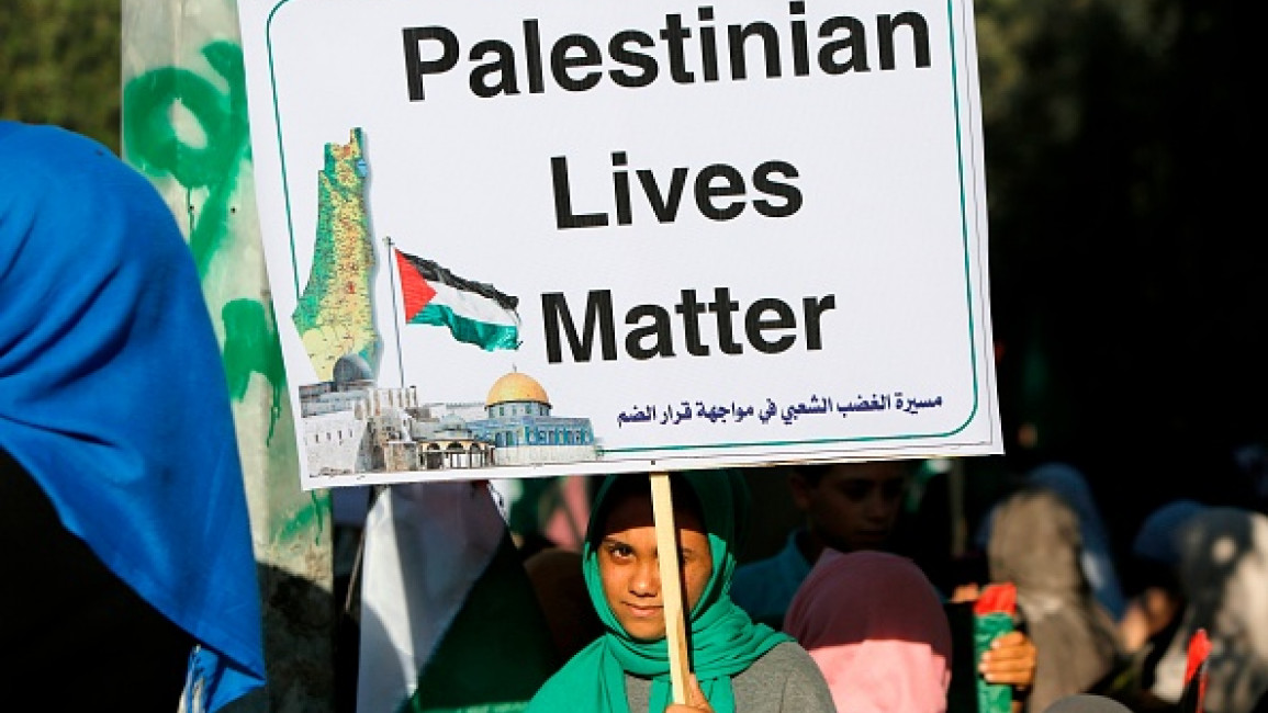 A Palestinian woman holding a placard takes part in a protest against Israel's plan to annex parts of the occupied West Bank, near the Erez crossing with Israel near Beit Hanun in the northern Gaza Strip on July 9, 2020. (MOHAMMED ABED/AFP/via Getty)