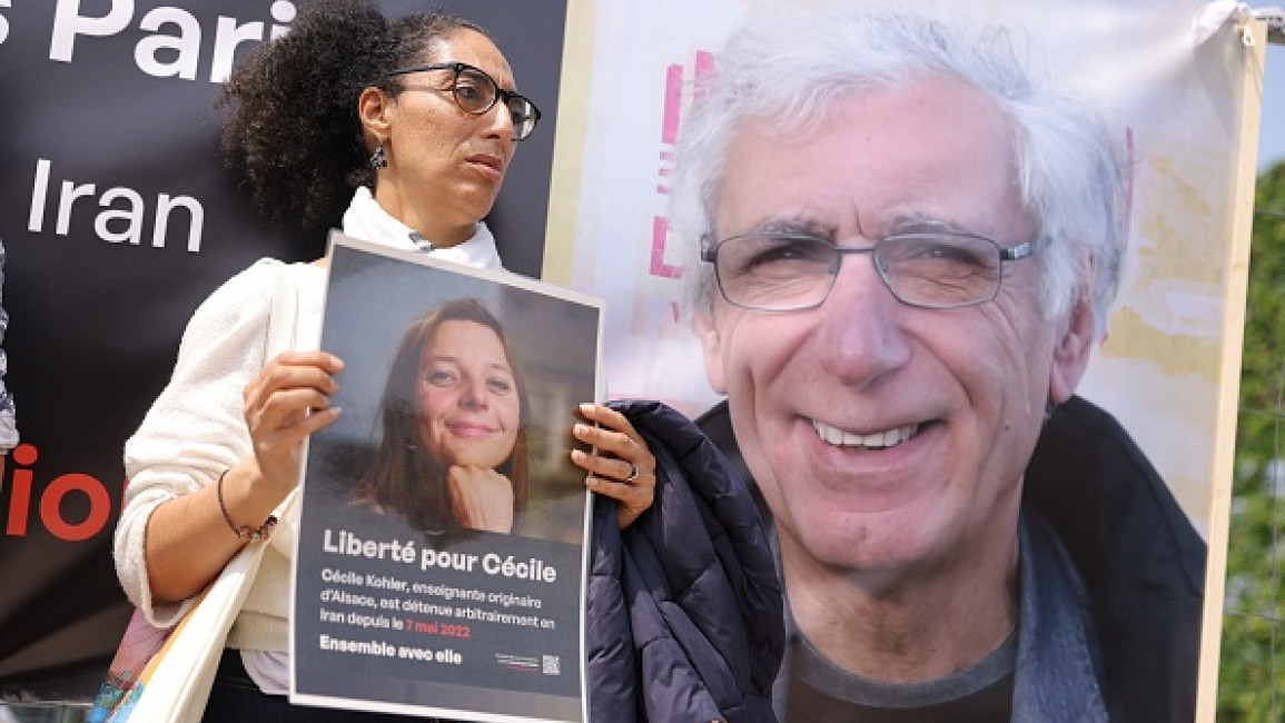 A supporter holds a placard bearing a portrait of French teacher Cecile Kohler, detained along with her partner Jacques Paris in Iran, during a rally in their support in Paris on May 14, 2023. (Photo by THOMAS SAMSON/AFP via Getty Images)