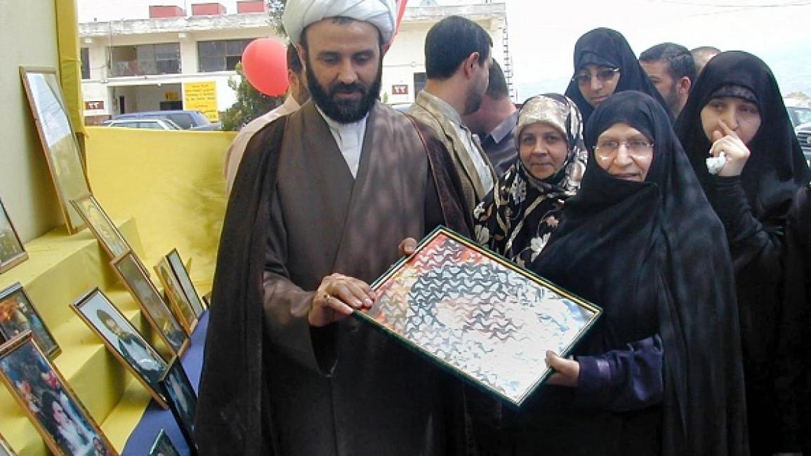 Zahraa (R), daughter of Ayatollah Ruhollah Khomeini, founder of the Iranian Islamic Republic, receives a painting of her father from Sheikh Nabil Qaouk in southern Lebanon 23 May 2002. (Photo by ALI DIYA/AFP via Getty Images)