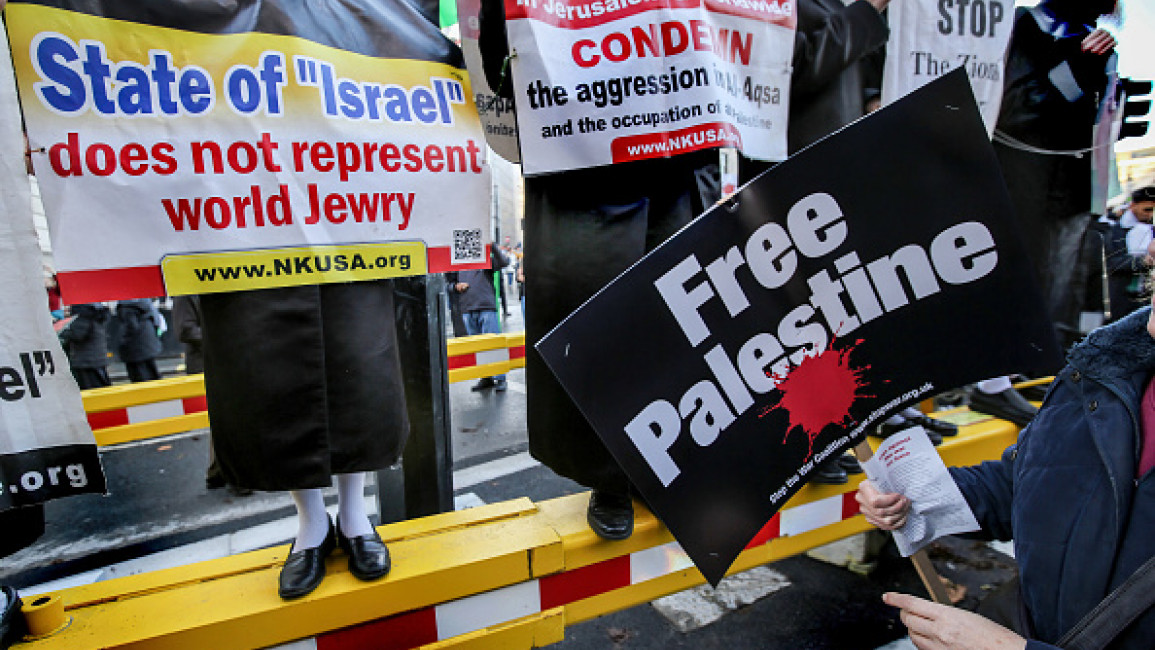 Anti Zionist placards are held with a Free Palestine sign near Trafalgar Square. 