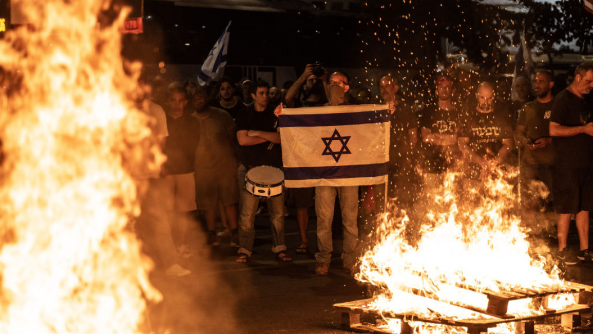 The protesters lit fires outside the Ministry of Defence building in Tel Aviv [Getty]