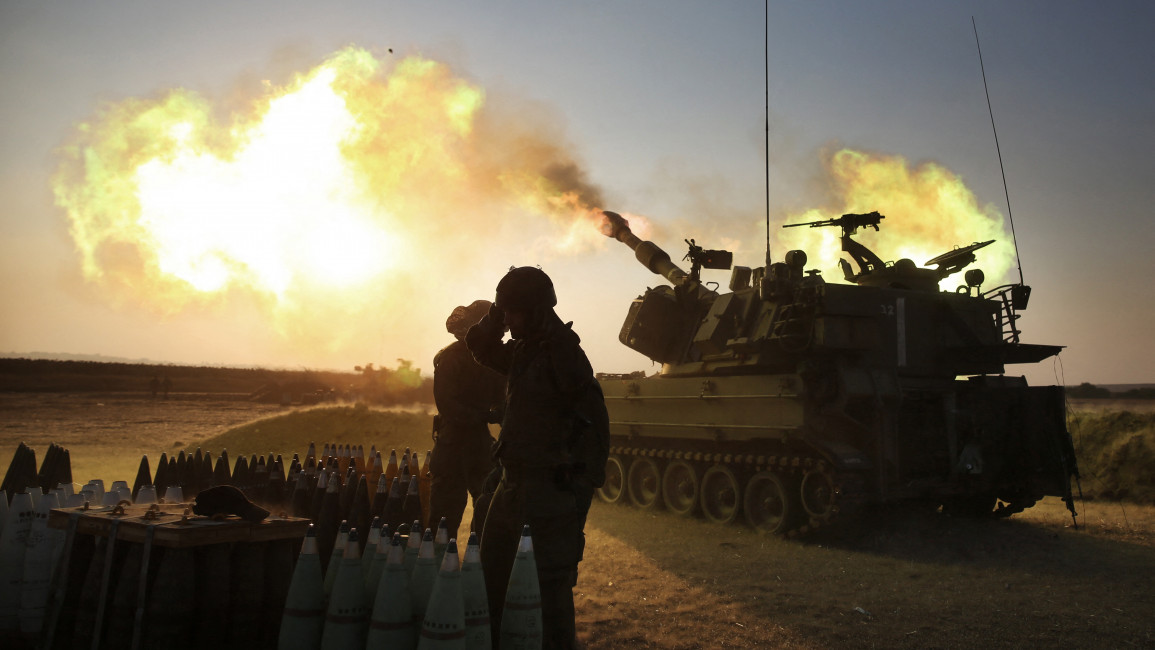 Israeli soldiers fir artillery cannons on the Gaza border