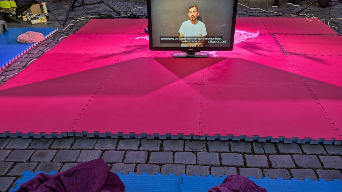 Pink mat with a screen on it with a man in a white t-shirt on the screen