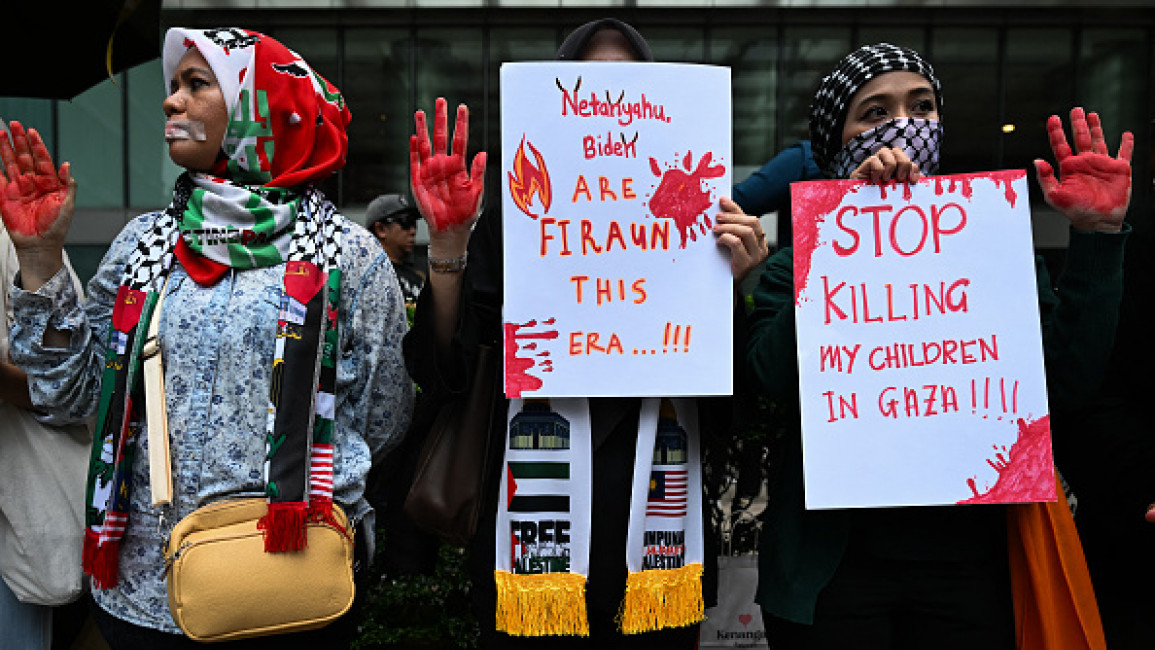 Protesters hold placards during a demonstration to support Palestinians during the American independence day dinner organized by the US embassy in Malaysia at the Mandarin Oriental Hotel in Kuala Lumpur on June 10, 2024.