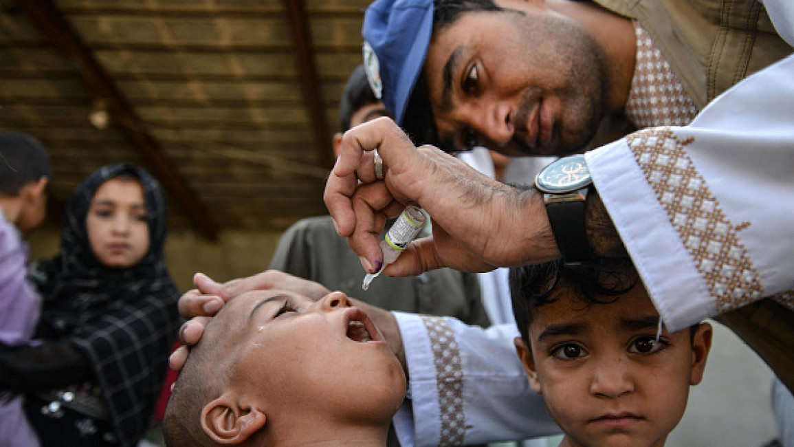  An Afghan health worker administers polio vaccine drops to a child during a polio vaccination campaign in Kandahar on July 8, 2024. 