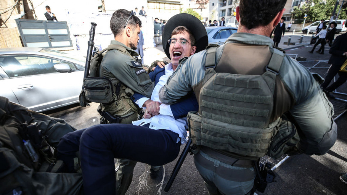 Israeli police officers intervene in Ultra-Orthodox Jews, also known as Haredim, who gather to stage a protest against mandatory military service in West Jerusalem, Israel, on August 21, 2024. (Photo by Saeed Qaq/NurPhoto via Getty Images)