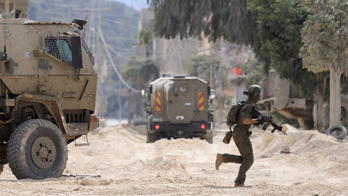 Israeli soldier takes cover during clashes in the occupied West Bank