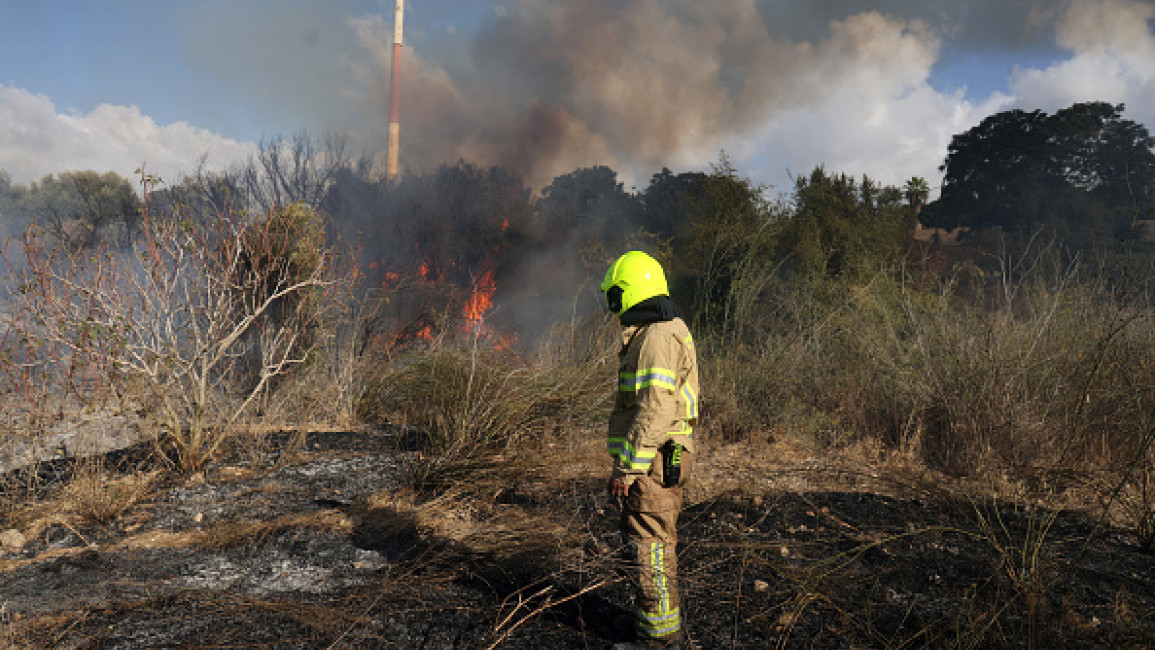 A first responder puts out a fire in an open in Lod near Tel Aviv, reportedly caused by a missile fired from Yemen on September 15, 2024.