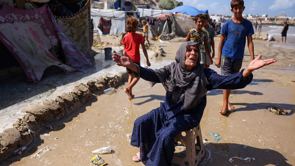 A displaced Palestinian woman reacts after her tent was damaged during a tide in Khan Yunis on the southern Gaza Strip on September 15, 2024