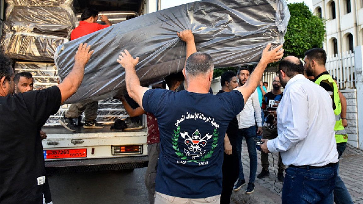 Volunteers unload beddings and supplies to accomodate people who fled their villages in southern Lebanon arriving at an art institute transformed to a shelter for displaced by conflict, in Beirut on September 23, 2024. (FADEL ITANI/AFP via Getty)