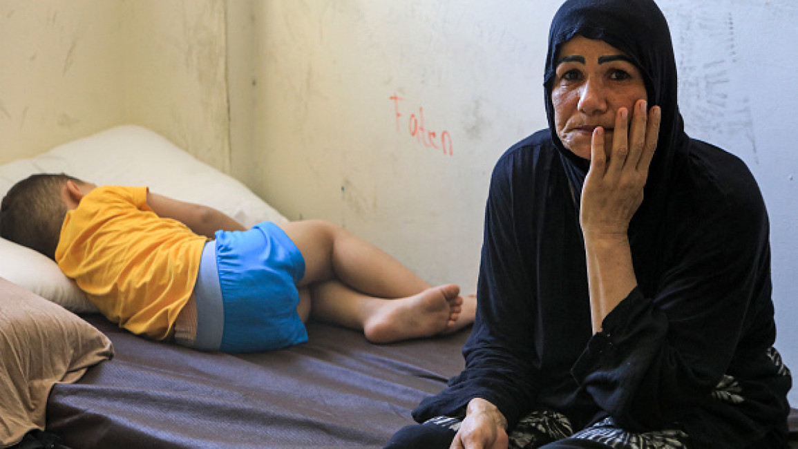 A child sleeps on a bed next to a woman, members of a family displaced by conflict from southern Lebanon taking refuge at a school turned into a temporary shelter in Beirut on September 24, 2024. (AFP via Getty Images)