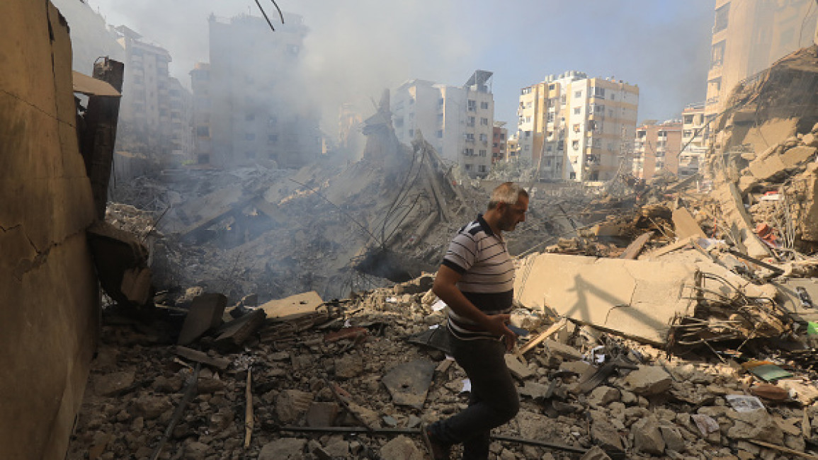 A man walks through the rubble as people check on September 28, 2024 the devastation in the Hadath neighbourhood of Beirut's southern suburbs in the aftermath of overnight Israeli airstrikes on the outskirts of the Lebanese capital. 