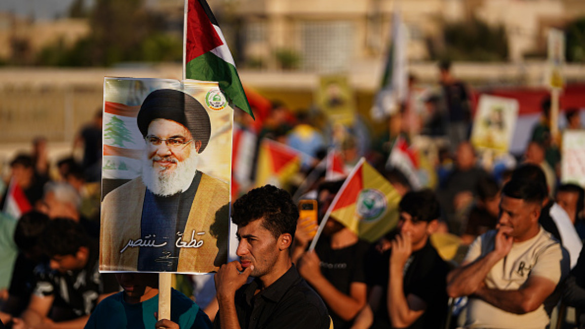 Supporter of Kataeb Sayyid al-Shuhada armed faction (member of the Hashed al-Shaabi / Popular Mobilisation Forces or PMF) hold a portrait of Hezbollah chief Hassan Nasrallah during a solidarity stand against the Israeli aggression on Lebanon and Palestine near the Great Mosque of Mosul.