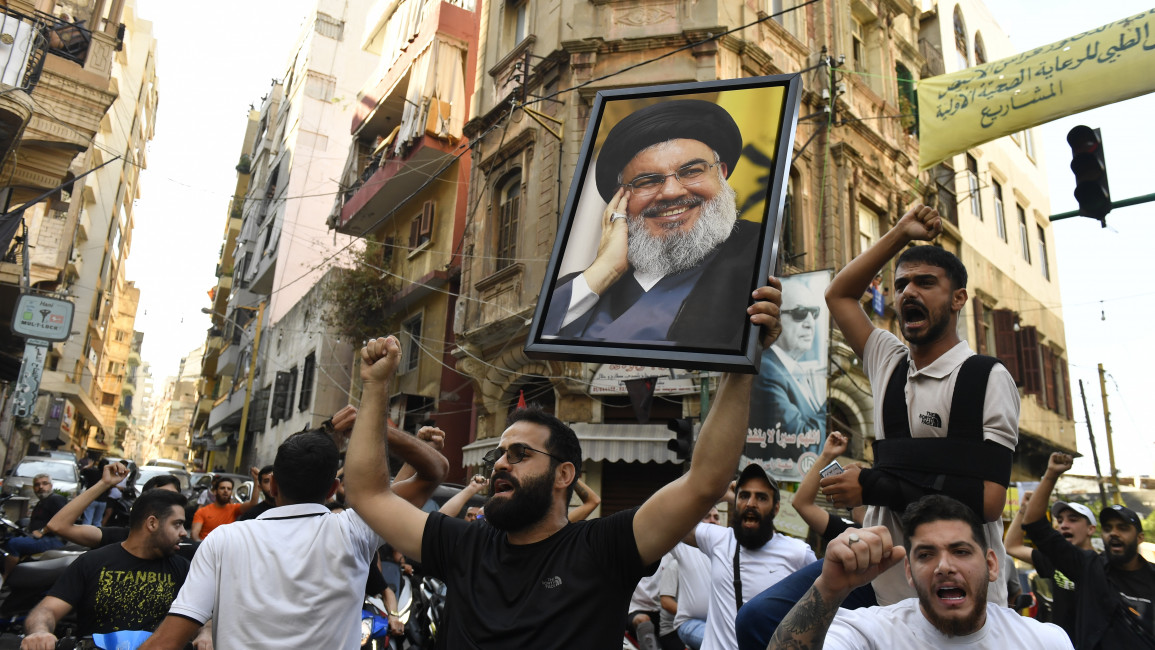 A group gather carrying Nasrallah's poster and chanting slogans following Hezbollah's statement after Hezbollah Secretary General Hassan Nasrallah was killed 