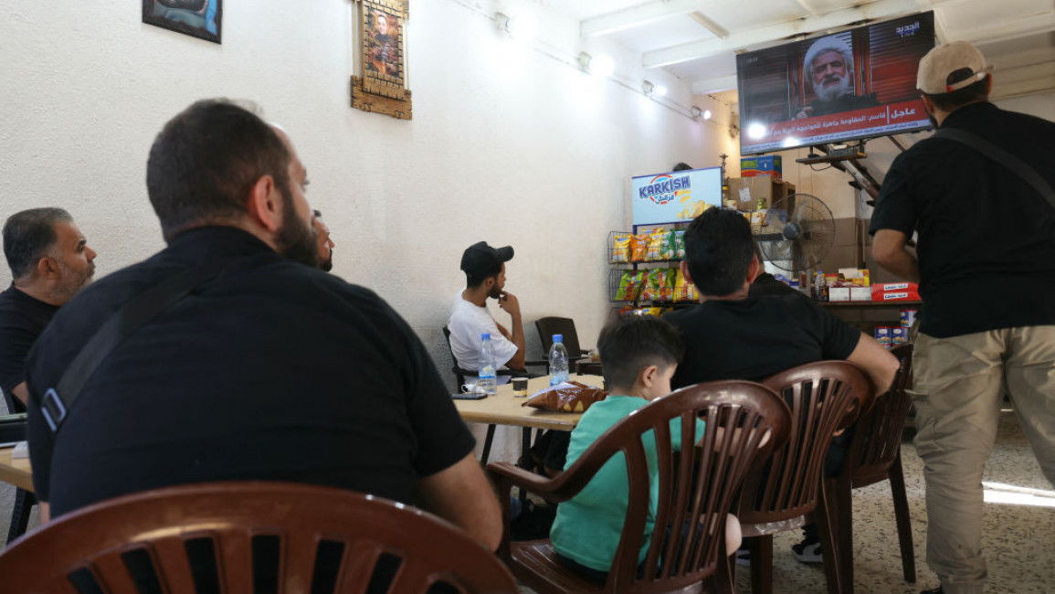 People watch Hezbollah deputy chief Naim Qassem give a speech in Beirut 