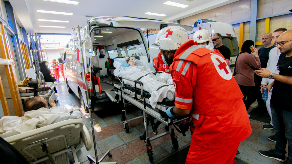 Ambulances and paramedics carry people wounded in Israeli bombing of Beirut to a hospital