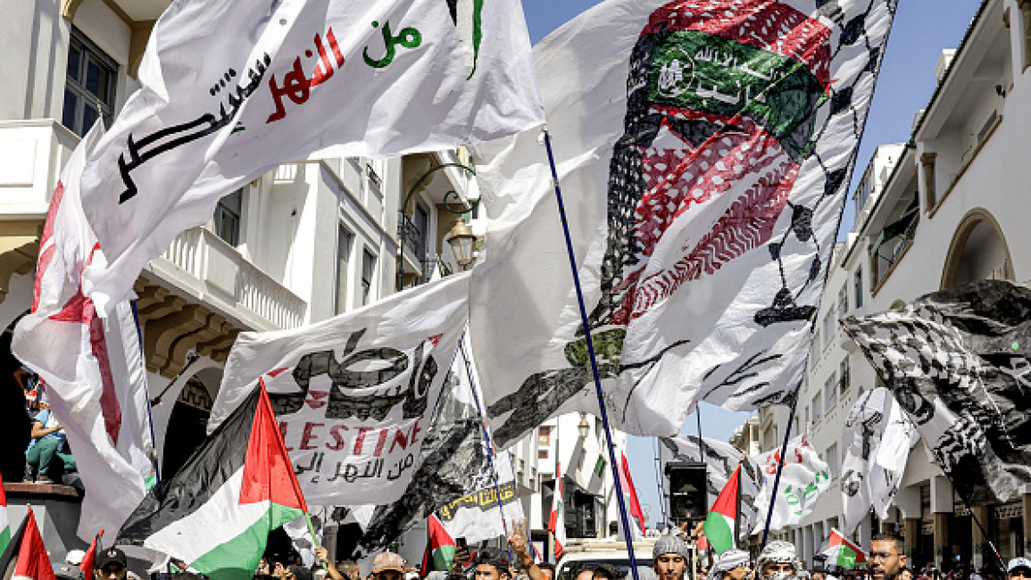 A Moroccan protestor holds a flag depicting Hamas' military spokesman Abu Obaida during a rally in solidarity with Palestinians in Morocco's capital Rabat on October 6, 2024