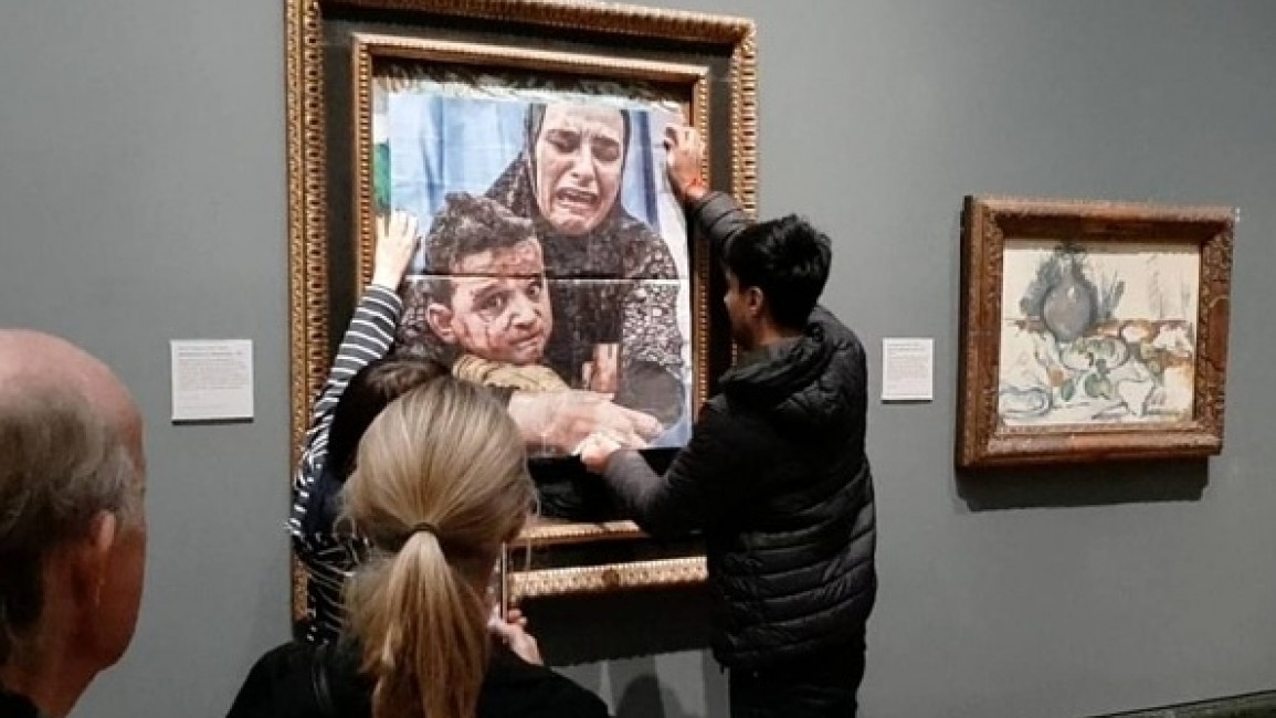 Youth Demand activists cover the Picasso painting 'Motherhood' with a photo of a Gazan mother and child to call for a mutual arms embargo on Israel at the National Gallery in London on October 09, 2024. (Youth Demand/Anadolu Agency via Getty Images)