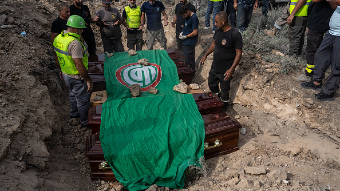 An Amal flag is draped over the coffins of five civil defence workers who were killed in an Israeli attack on the southern Lebanese village of Derdghaiya, during their funeral on October 10, 2024 in Tyre, Lebanon.