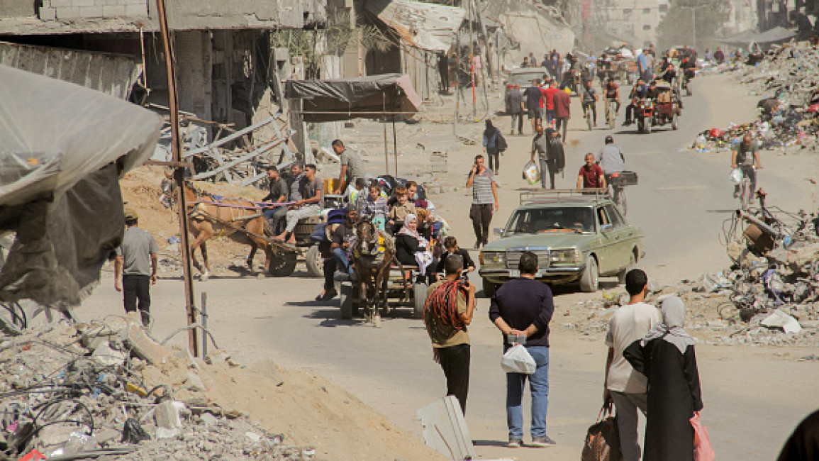 Palestinians carry their belongings as they flee areas north of Gaza City in the northern Gaza Strip on October 12, 2024. (Photo by MAHMOUD ISSA/Middle East Images/AFP via Getty Images)