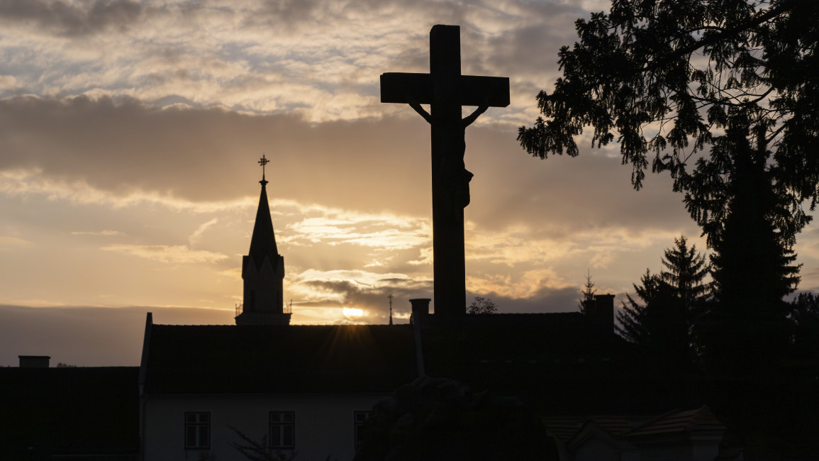 Sunset, silhouette of a cross and a church tower, Jakobifriedhof, Le