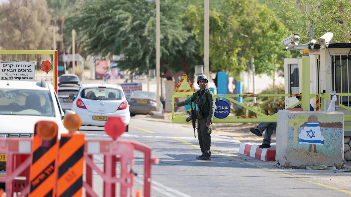 An Israeli soldier stands at a checkpoint at the entrance of Ein Tamar in southern Israel where the army said two attackers entered the area from Jordan