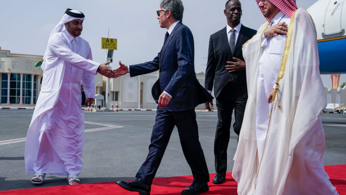 US Secretary of State Antony Blinken (C) is greeted by an official as US Ambassador to Qatar Timmy Davis (2R) and Qatari Ministry of Foreign Affairs Chief of Protocol Ibrahim Fakhroo (R) walk behind upon his arrival in Doha 