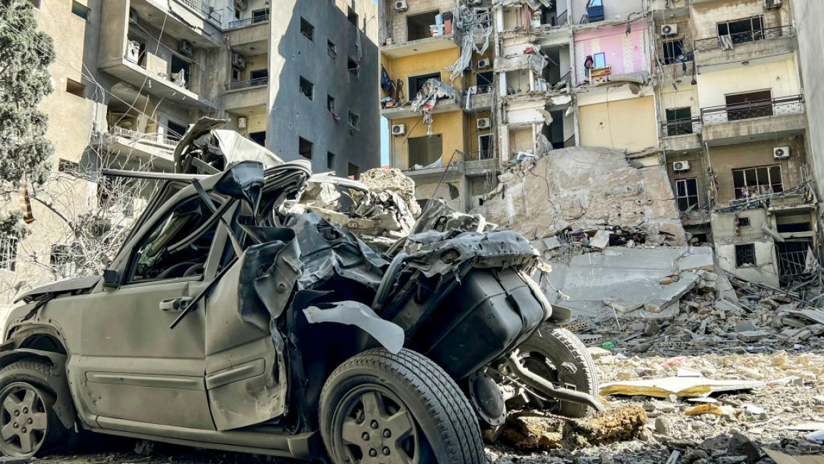  destroyed vehicle is pictured near a building with exposed rooms after a portion of it collapsed following an Israeli air strike the previous day in Lebanon's southern city of Tyre