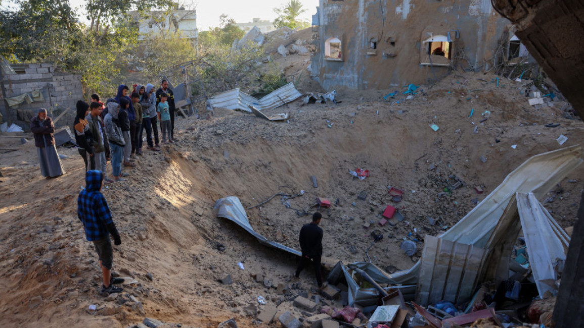 People inspect the damage at the site of an Israeli strike that targetted an area in Khan Yunis on the southern Gaza Strip