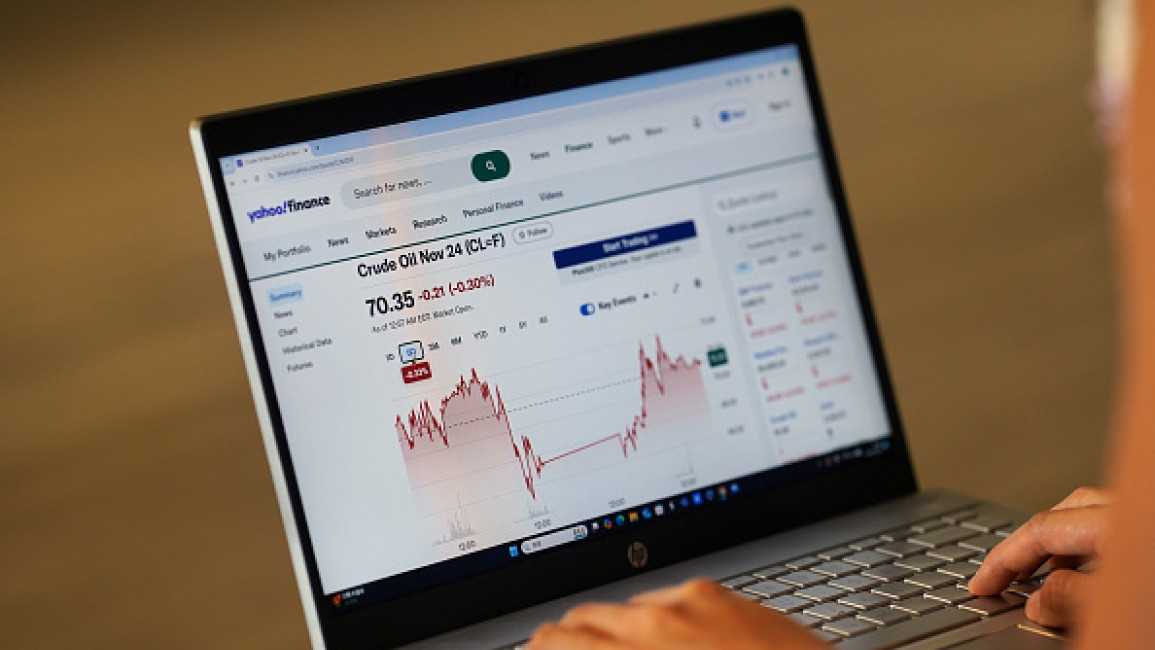 , A woman browses Yahoo Finance website to check Crude Oil Dec 24 stock market price quotes graph on her laptop.