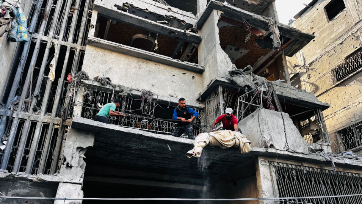 Palestinian first responders remove a body from the rubble of a building following an Israeli strike in Beit Lahia, in the northern Gaza Strip