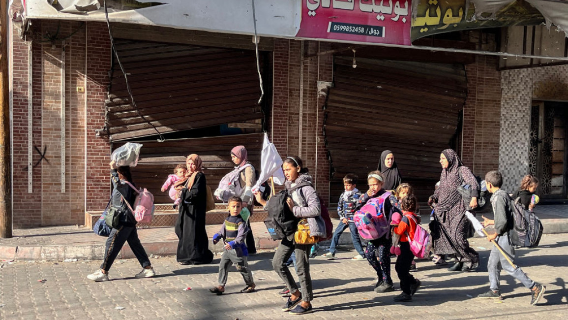 Displaced Palestinians walk in Beit Lahia