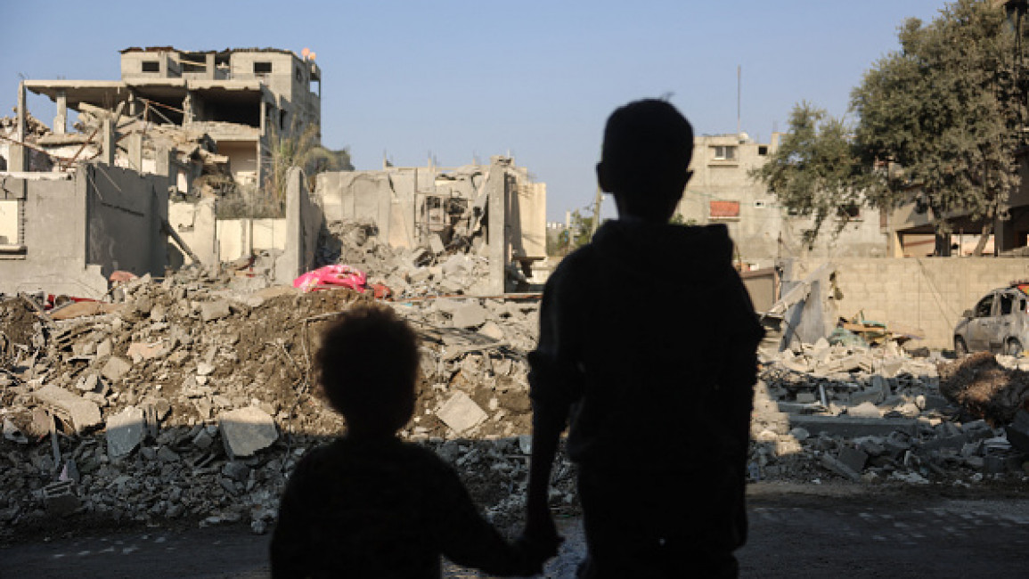 Children stare at the destruction following an Israeli strike in the Nuseirat refugee camp in the central Gaza Strip on November 7, 2024