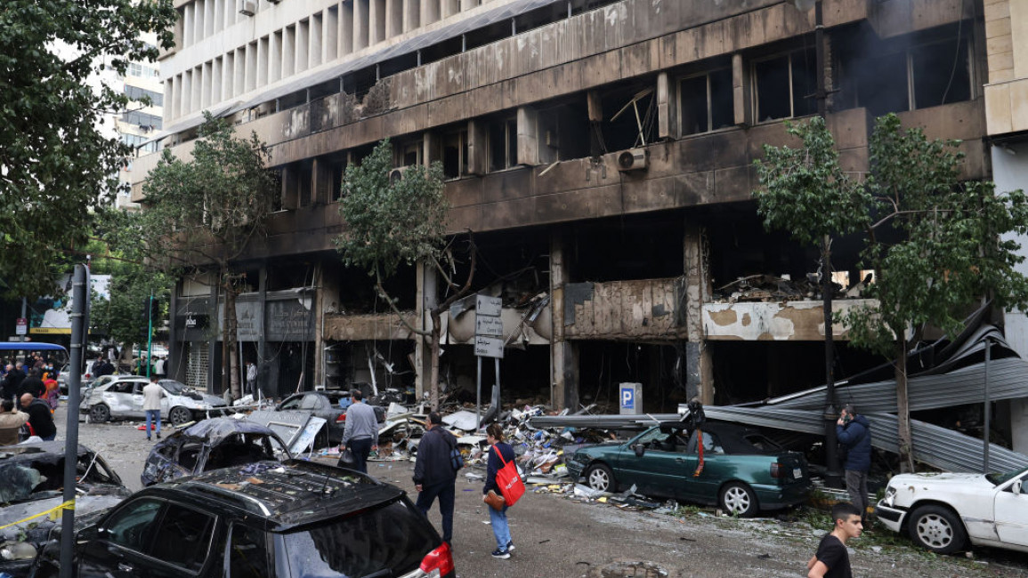 People inspect the damage to a building, targeted in an Israeli airstrike the previous day, in Beirut's Mar Elias Street