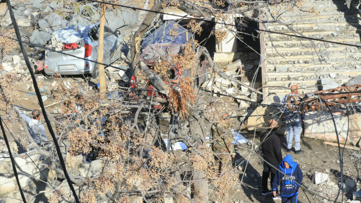 People inspect destruction at the site of an overnight Israeli airstrike that targeted the southern Lebanese coastal town of Sarafand