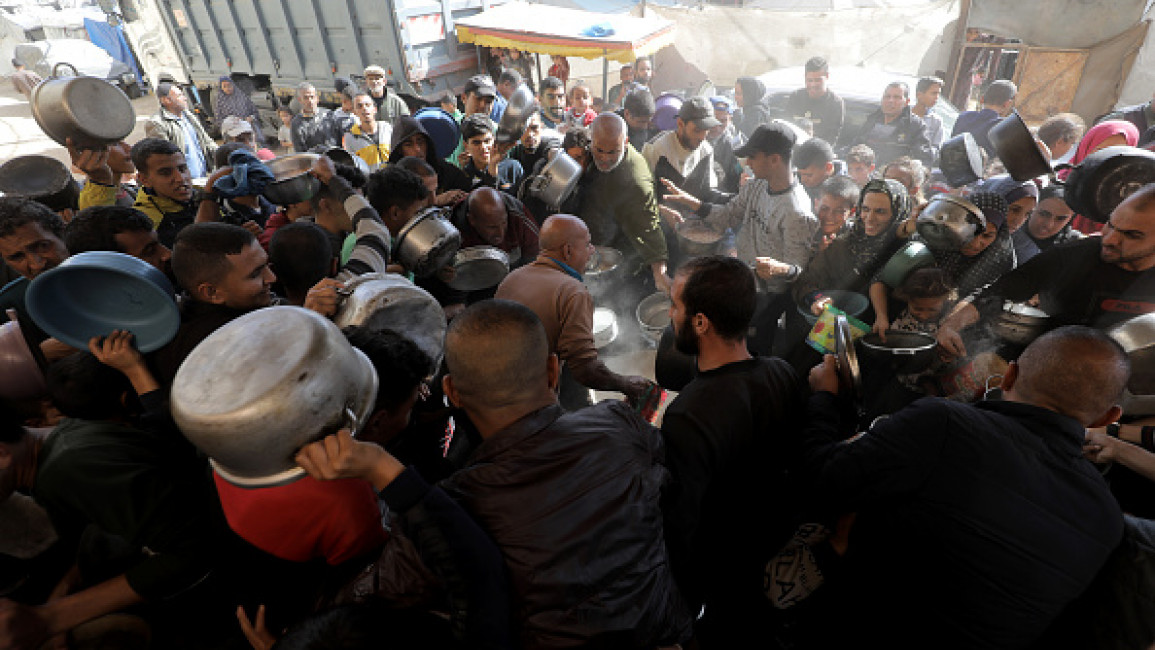 Palestinians, who take refuge in Bureij Refugee Camp to escape from Israeli attacks, wait to receive meal, distributed by charity organizations in Deir al-Balah, Gaza on November 20, 2024. (Photo by Moiz Salhi/Anadolu via Getty Images)