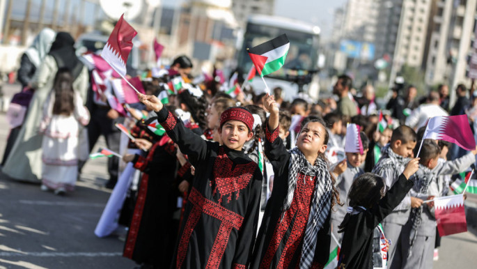 Palestinian children wave flags to support the 2022 FIFA World Cup held at Qatar, in Gaza [Getty Images]